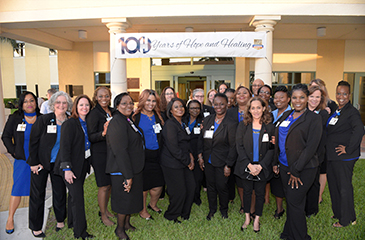 The staff stands out front of the Healey Center under a 100 years of hope and healing banner.